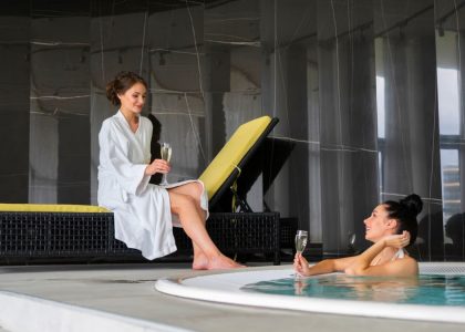 Two women enjoy a luxurious poolside moment with champagne, embodying relaxation and leisure.